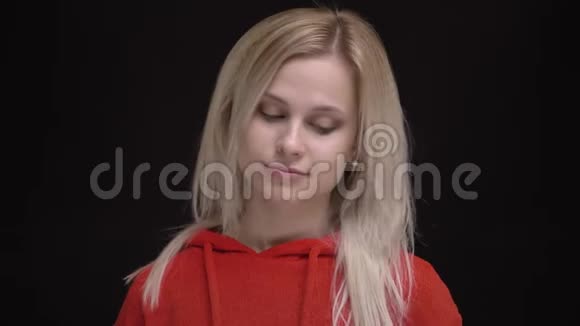 白毛白种人年轻女孩穿着红色毛衣看手表的肖像对等待黑色感到厌倦视频的预览图