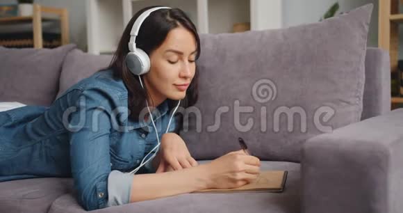 创意女孩通过耳机听音乐在家画画视频的预览图