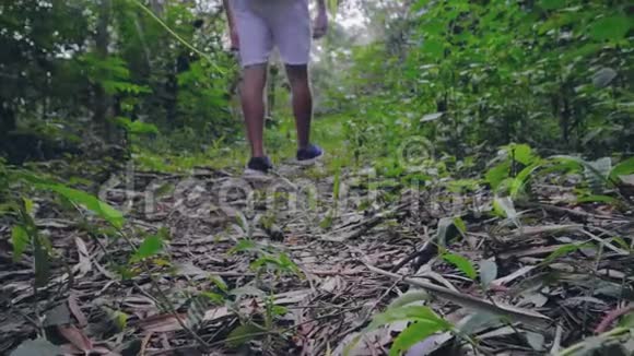 在雨林中漫步的游客男女的腿在热带丛林徒步旅行的情侣视频的预览图