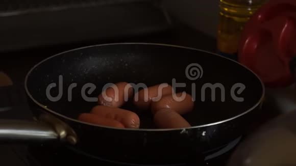 女性手把美味的烤猪肉美食香肠放在热黑锅的特写厨房里视频的预览图