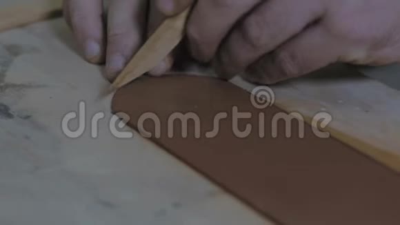 泥工师傅用木刀从一条泥条上切边手工泥茶壶宜兴为茶道紫色紫色视频的预览图