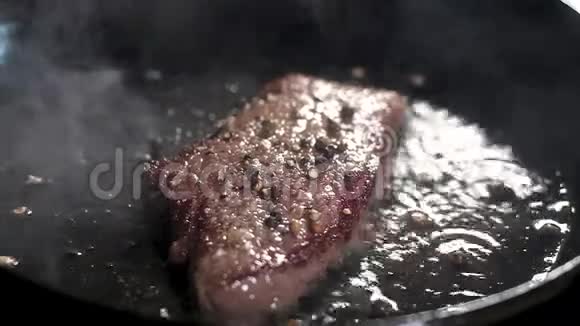 大理石胡迪尼的美味可口的牛排用平底锅和橄榄油炒沸腾的油和大量的蒸汽视频的预览图