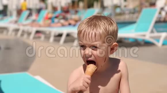 一个小孩子在暑假在游泳池附近吃巧克力冰淇淋视频的预览图
