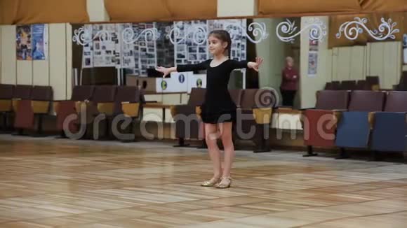 九岁的女孩在旧舞厅里参加体育舞蹈视频的预览图