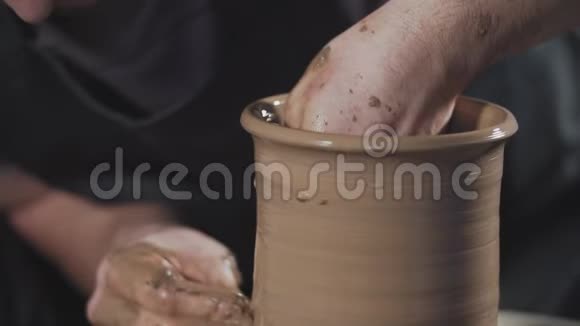 关闭陶工与粘土在陶工的车轮男人轻轻地创造酒壶视频的预览图