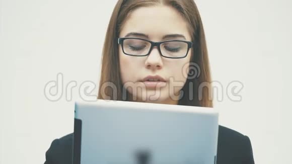 女人用数字平板电脑快乐地孤立在白色的背景上关注平板电脑和企业的工作视频的预览图