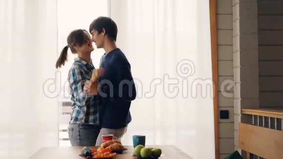可爱的一对男女在厨房里跳舞接吻穿着休闲服装享受在一起的时光视频的预览图