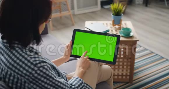 个人手持平板电脑触摸绿色模拟屏幕使用设备在家视频的预览图
