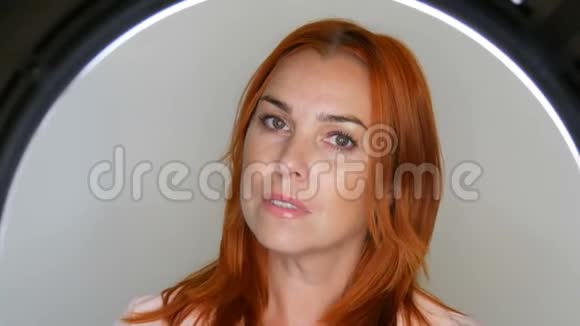 漂亮的红发成年中年女性模特在摄影棚的镜头前摆姿势视频的预览图