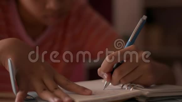 合上一个小女孩写在笔记本上的手女学童在日记上做笔记做作业视频的预览图
