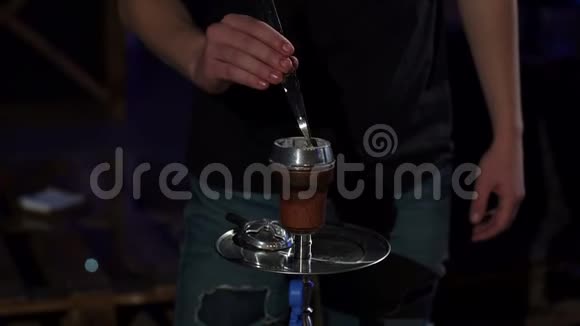 一个人的特写镜头在一个黑暗的钩子酒吧里换了一块烧焦的煤视频的预览图