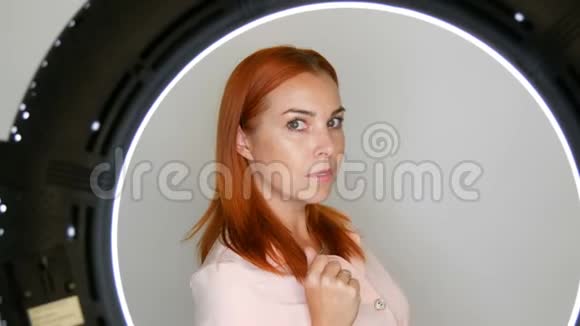 漂亮的红发成年中年女性模特在摄影棚的镜头前摆姿势视频的预览图