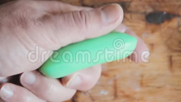 一个人拿着一块绿色的肥皂在湿的手掌里拉瑟的手浴室视频的预览图