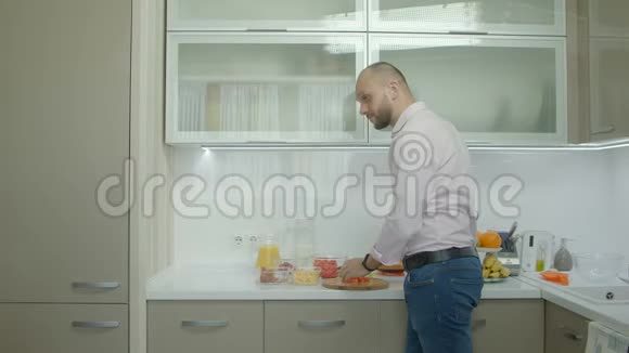 微笑的父亲在厨房做早餐视频的预览图