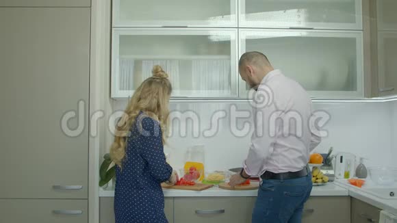愉快的休闲情侣在厨房准备食物视频的预览图