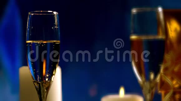 燃烧的蜡烛倒映在香槟酒杯里视频的预览图