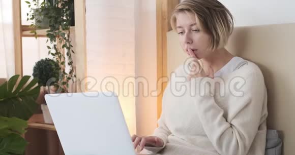 女人在床上看手提电脑视频的预览图