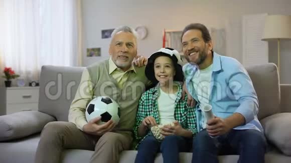 爷爷爸爸和十几岁的儿子在家为国家足球队加油爱好视频的预览图