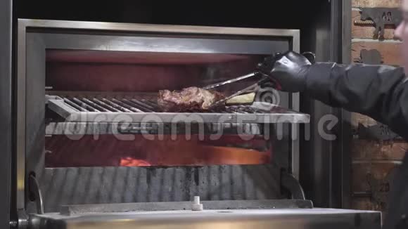 厨师戴着黑色手套打开烤箱烤架在烤架上准备炸肋骨把它翻转到另一边关门视频的预览图