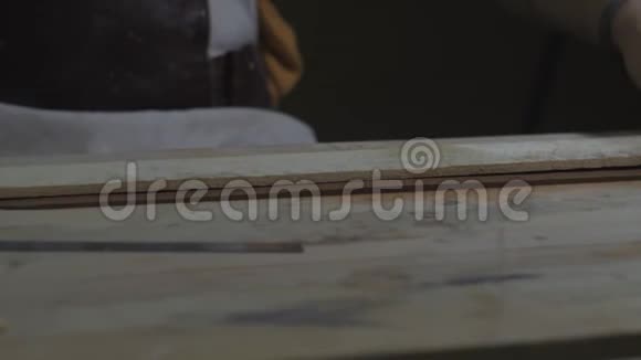 泥匠用一把刀在木棒下切割一条均匀的粘土手工泥茶壶宜兴为茶道紫色紫色视频的预览图