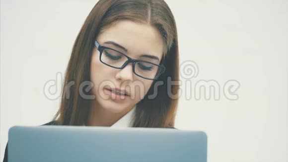 女性使用数字平板电脑快乐隔离在白色背景上关注平板电脑和电脑的工作视频的预览图