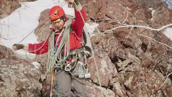 登山者测量一根长绳把它扔到肩膀上他正在准备危险的下降背景资料视频的预览图