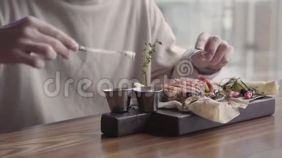 帅哥坐在豪华餐厅里吃着美味可口的烤鱼和蔬菜视频的预览图