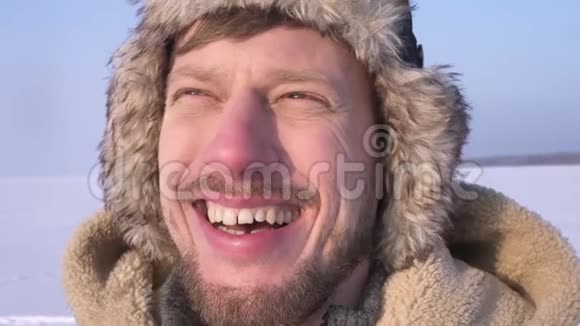 穿着头巾和外套的中年探险家的特写镜头微笑地看着太阳对着雪漠的镜头视频的预览图