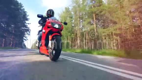 森林路上有一个人骑自行车摩托车手驾驶他的摩托车视频的预览图