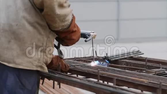 一名工人正在用空心电极焊接钢筋过程的侧面视图视频的预览图