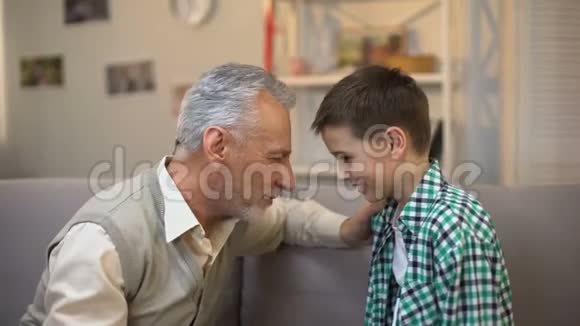 老人和男孩抚摸前额爷爷和孙子之间的友谊视频的预览图