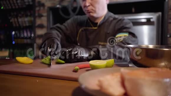 专业厨师用锋利的刀在木板上切碎青黄椒和石灰准备沙拉视频的预览图