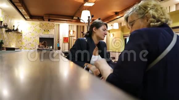 那个女人正把杯子和杯子放在咖啡馆的柜台上视频的预览图