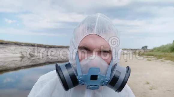 一个穿着防护服和呼吸器的人怀疑地看着摄像机视频的预览图