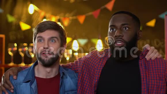 令人兴奋的多种族男性朋友在酒吧中为喜爱的运动队进球而欢呼视频的预览图