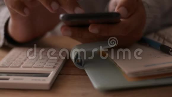 关闭商人的手使用手机在工作桌上进行社交在线视频的预览图