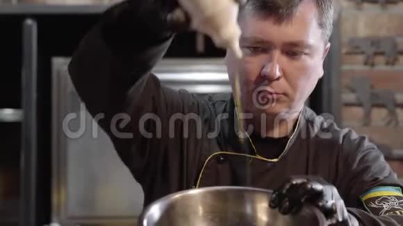 黑手套厨师肖像金属盘子腌料和酱汁均匀浇水并与甜椒混合视频的预览图