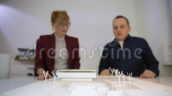 两位建筑师在一座模型房子A的后面握手视频的预览图