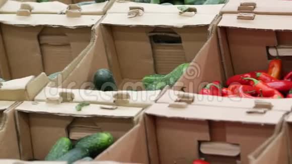 超市橱窗上有蔬菜的瓦楞纸箱新鲜黄瓜和红黄瓜视频的预览图