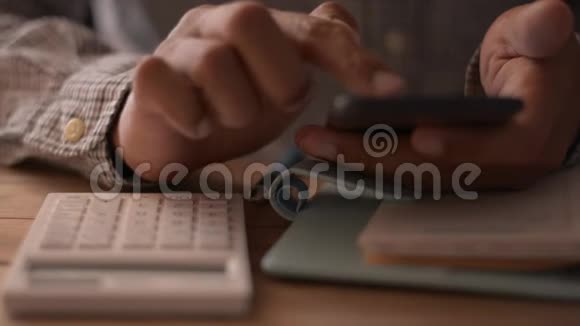 关闭商人的手使用手机在工作桌上进行社交在线视频的预览图