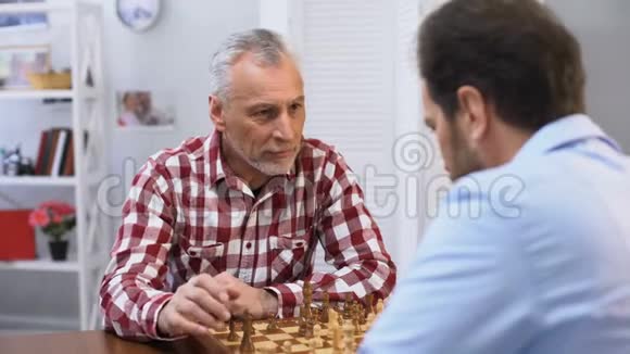 父亲和儿子在象棋周末爱好和休闲活动中竞争传统视频的预览图