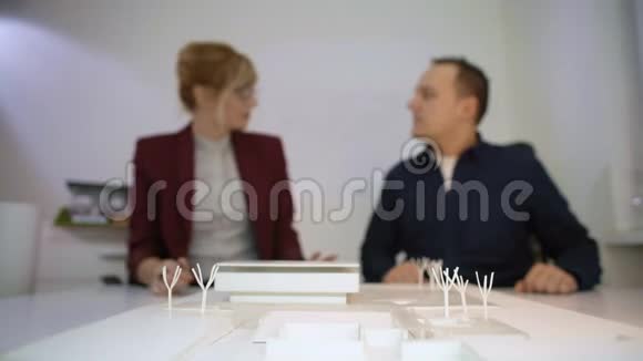 两位建筑师在一座模型房子A的后面握手视频的预览图