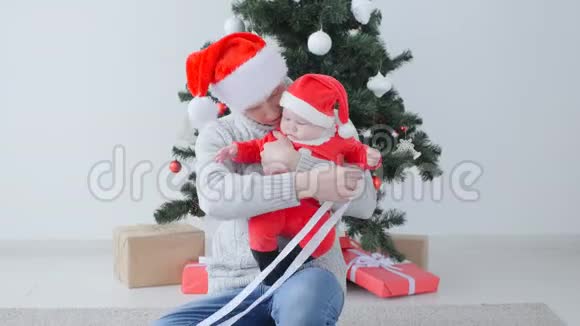 圣诞节的概念可爱的孩子在爸爸手圣诞老人的帽子视频的预览图