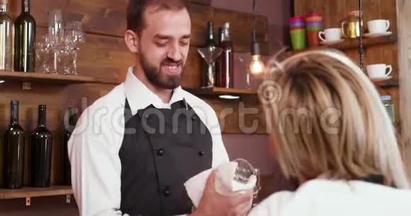 一个年轻的咖啡师在擦玻璃的时候视频的预览图