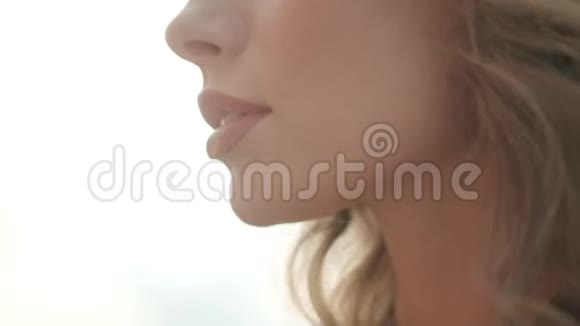 女性嘴唇特写阳光下一个迷人女孩的肖像视频的预览图