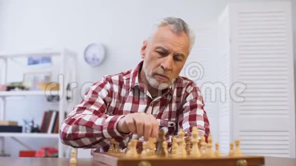 衰老忧郁的男性独自下棋在养老院忍受孤独视频的预览图