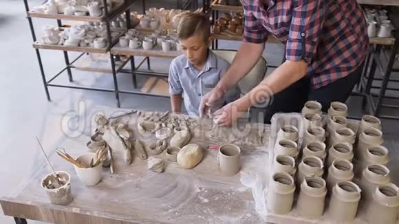 白人关心的父亲帮助小儿子制作陶瓷花瓶视频的预览图