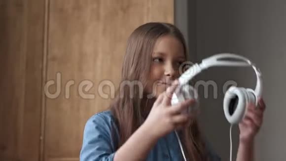 快乐的儿童听音乐或可爱的微笑女孩带耳机视频的预览图
