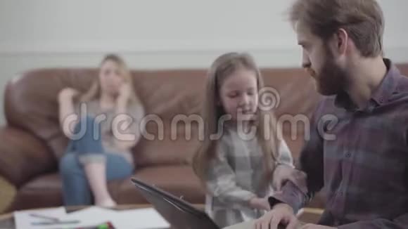 有胡子的人用笔记本电脑近距离工作的肖像小女孩摸着男人要钱的手刺激性视频的预览图