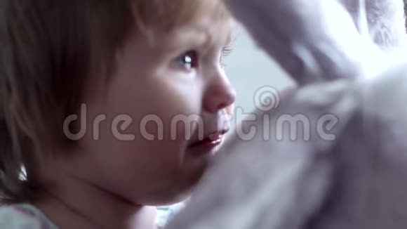 小女孩坐在一个柔软的大玩具旁边慢动作地哭得很近视频的预览图